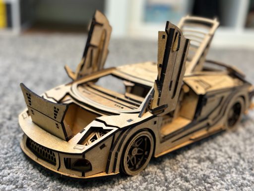 Modell eines Sportwagens aus Holz, Türen und Motorhaube geöffnet.