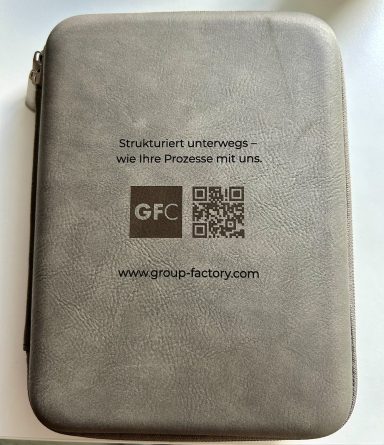 Graue, strukturierter Travel Organizer Hülle mit Logo und QR-Code Laserung.