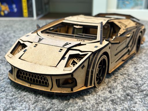 Modell eines sportlichen Autos aus Holz, detailliert und mit sichtbaren Bauteilen.